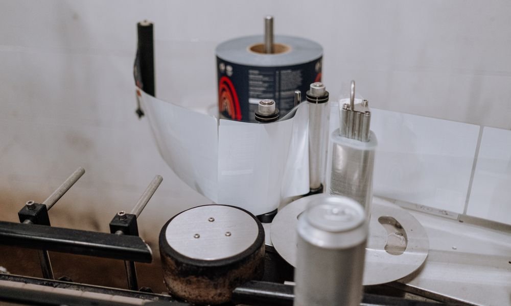 Close-up of a label roll feeding into a bottle labeling machine