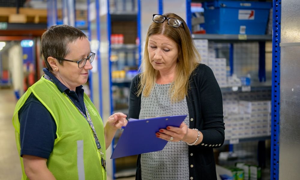 Two inspectors reviewing an inspection report in a warehouse
