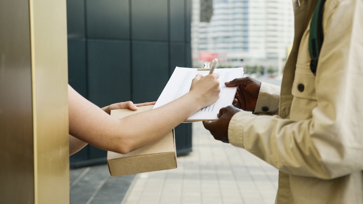 Courier handing over a package with a signature at the door