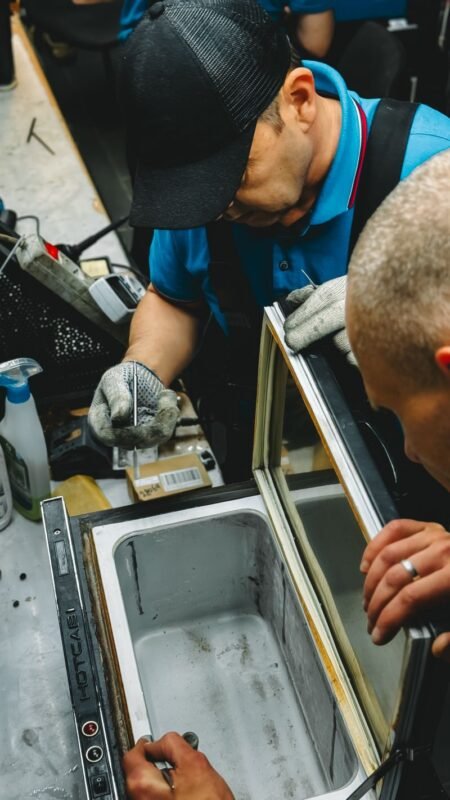 A technician servicing a commercial freezer unit