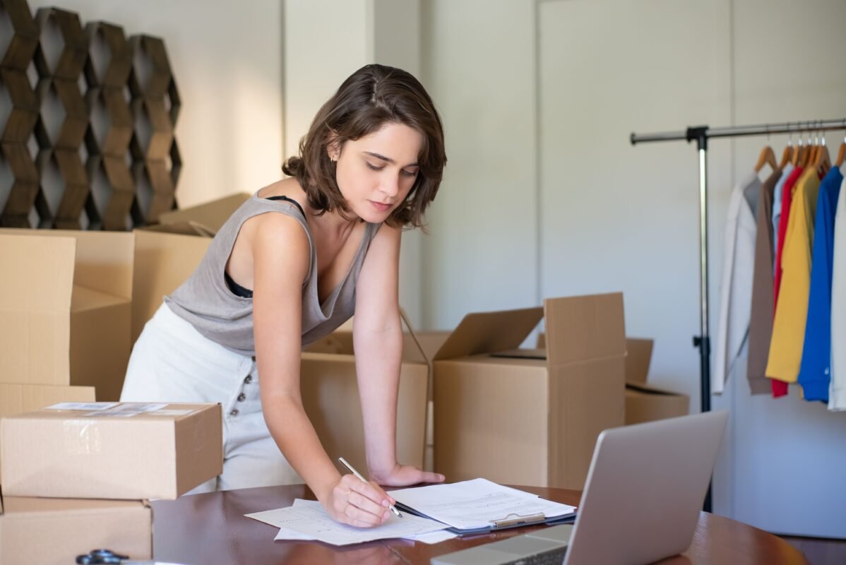 Ecommerce entrepreneur managing shipping boxes and paperwork