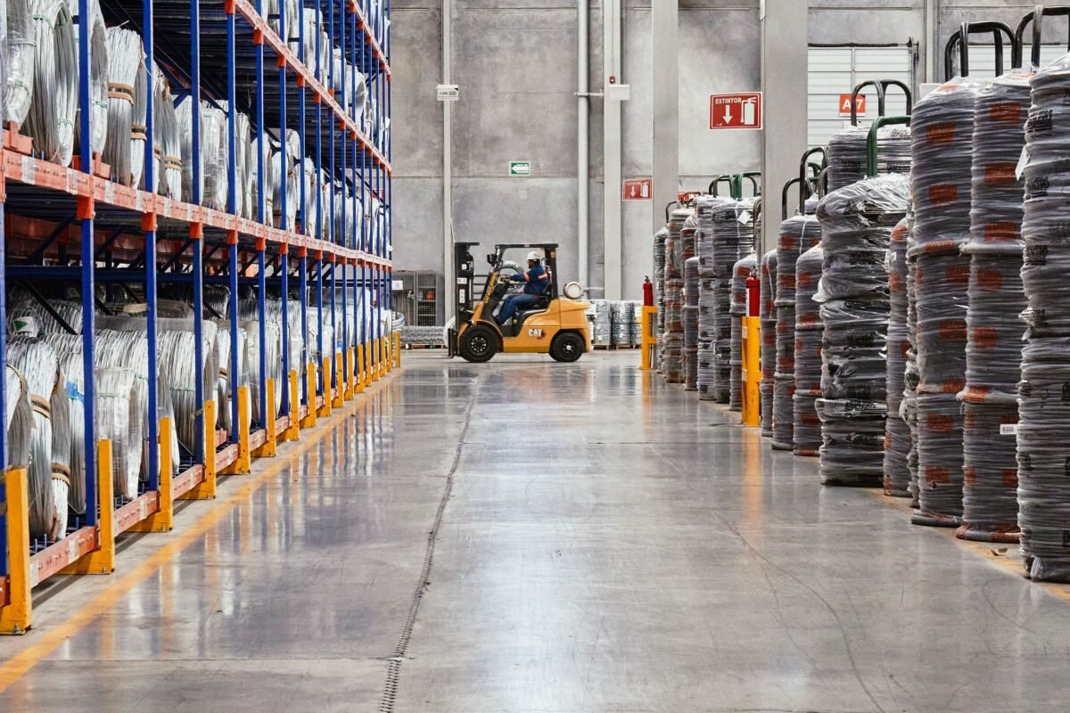 Forklift moving through a warehouse aisle with pallet racking