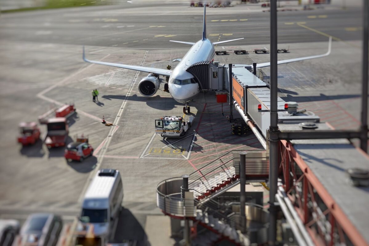 Commercial aircraft parked at airport jet bridge during peak season ground operations
