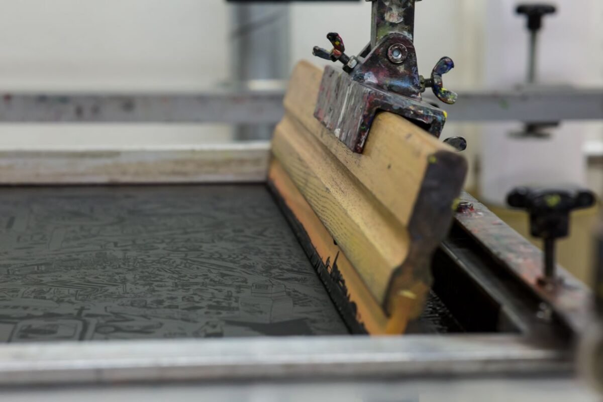 Screen printing squeegee resting on a print frame