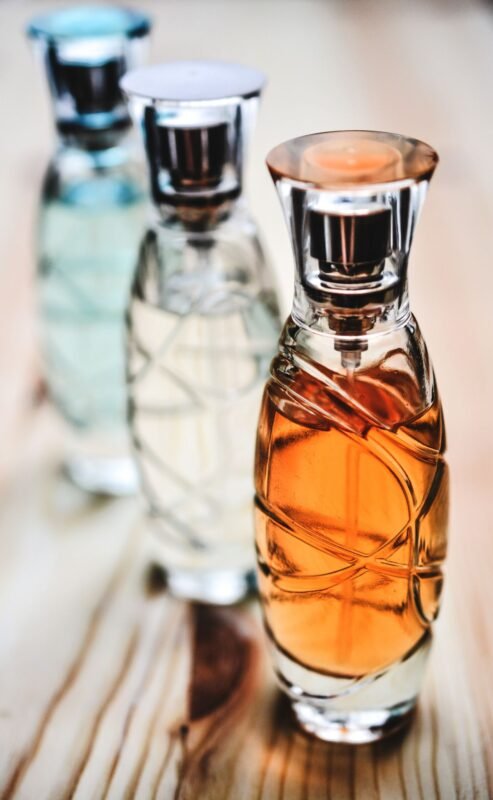 Glass perfume spray bottles on a wooden table