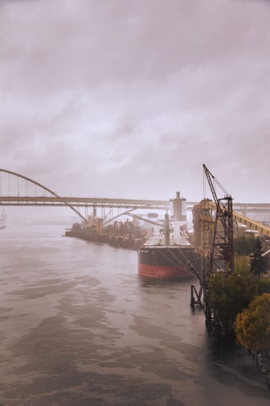 Cargo ship moored at a port berth beside loading cranes