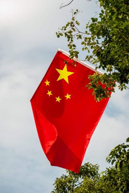 Chinese national flag flying against an autumn sky