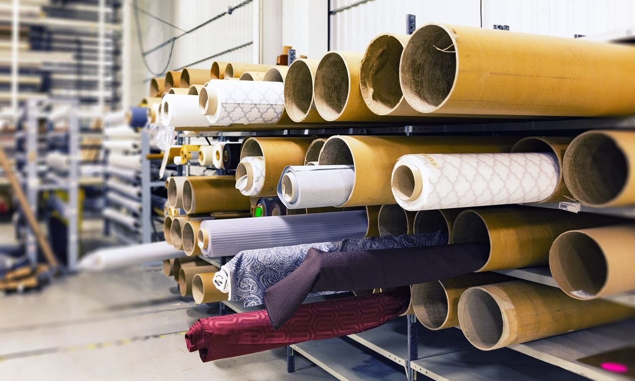Rolls of imported fabric stored on racks in a textile warehouse