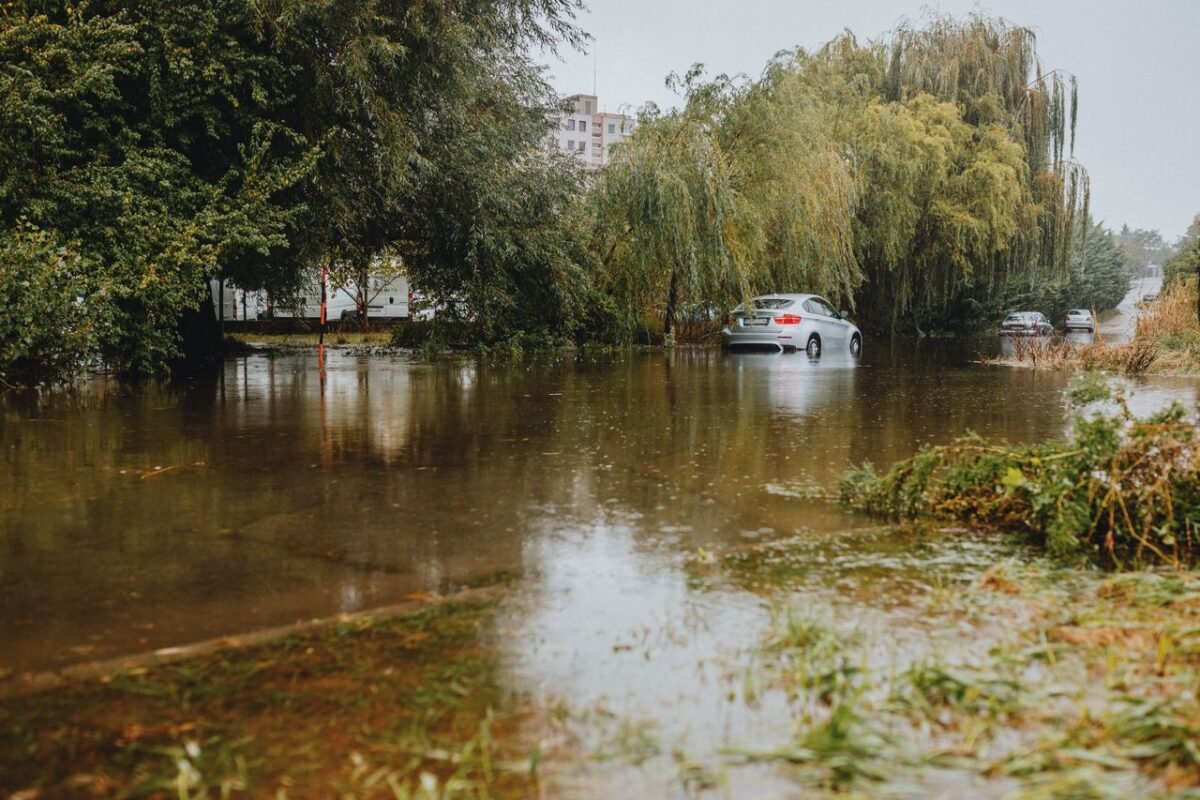 Flooded street with a car standing in water after heavy rain