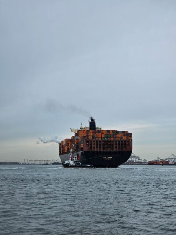 Container ship being guided by tugboat, relevant to sea freight bunker fuel surcharges