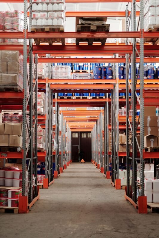 Tall warehouse racking aisle stocked with palletized goods
