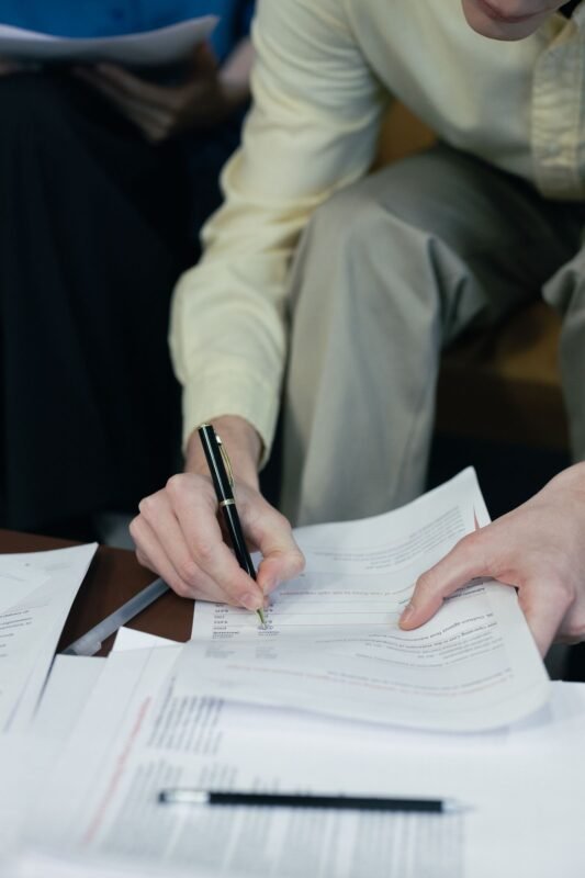 Accountant reviewing financial statements and signing paperwork
