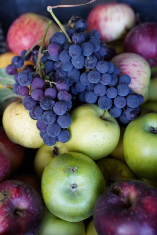 Fresh grapes and apples in a crate