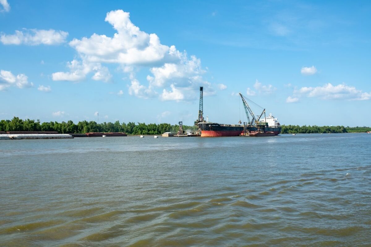 Cargo ship berthed at a river port with cranes