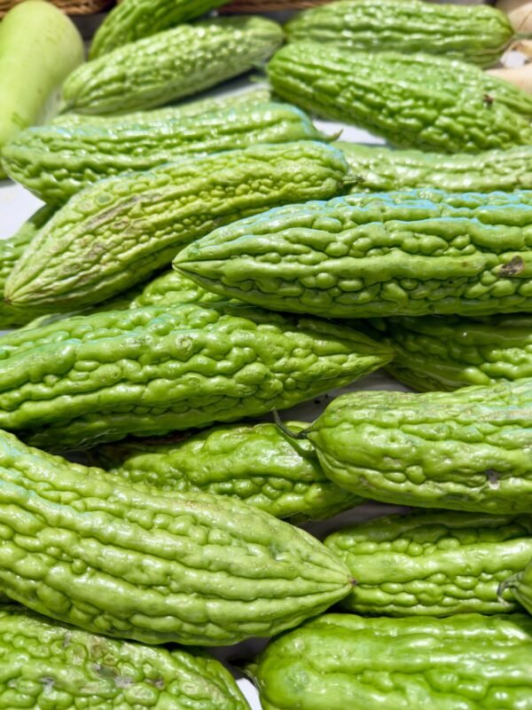 Fresh bitter gourd korola stacked at a vegetable market