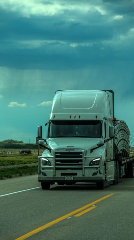 Freight Truck Hauling a Loaded Flatbed Trailer on Highway