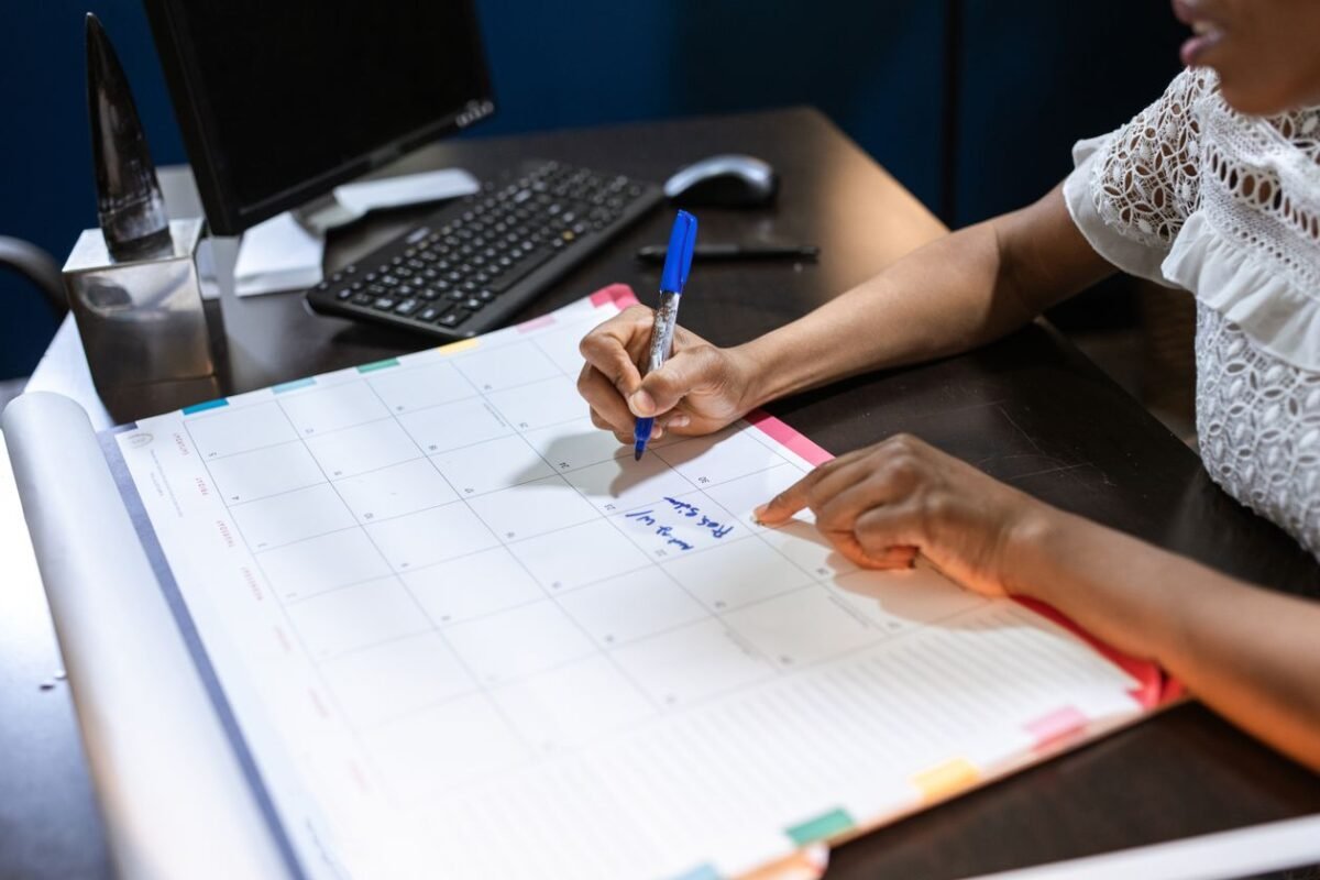 Planning a monthly schedule on a desk calendar