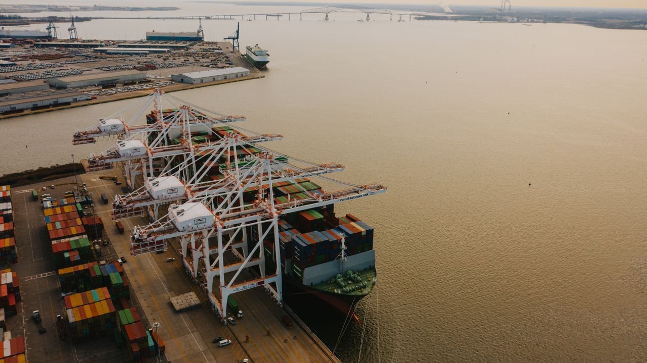 Container ship berthed under quay cranes after arrival at port