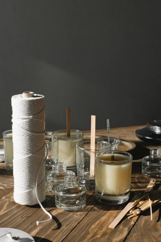 Wax poured into glass jars with cotton wick roll for candle making