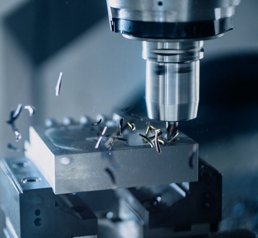 CNC milling spindle cutting a steel block with chips flying