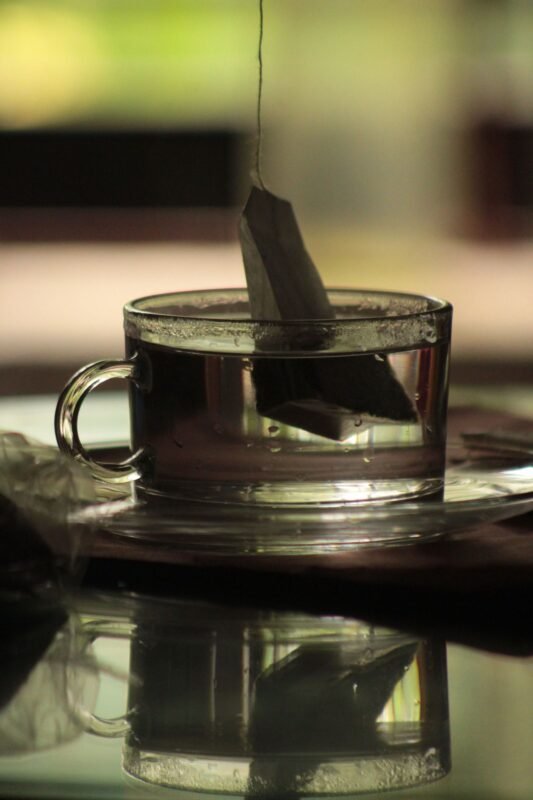Tea bag brewing in a clear glass cup, the end product of a tea packaging line