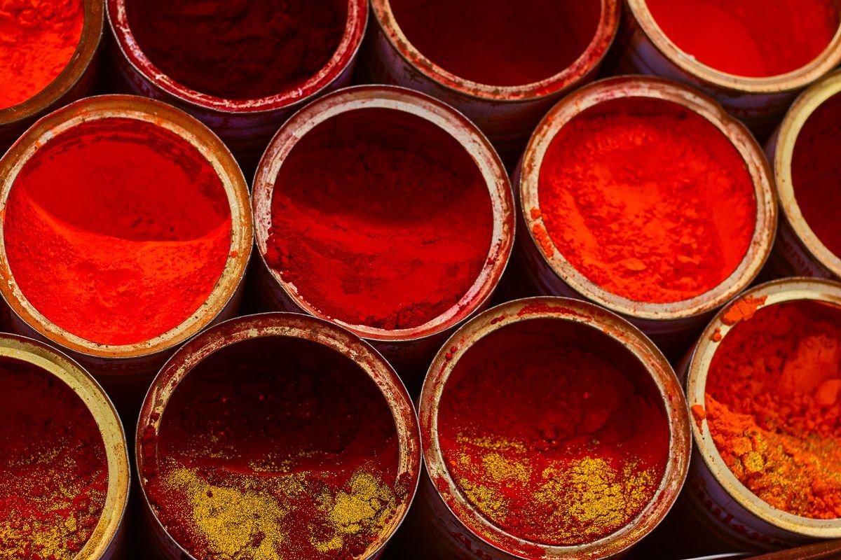 Ground red chilli and turmeric powder in open tins after grinding