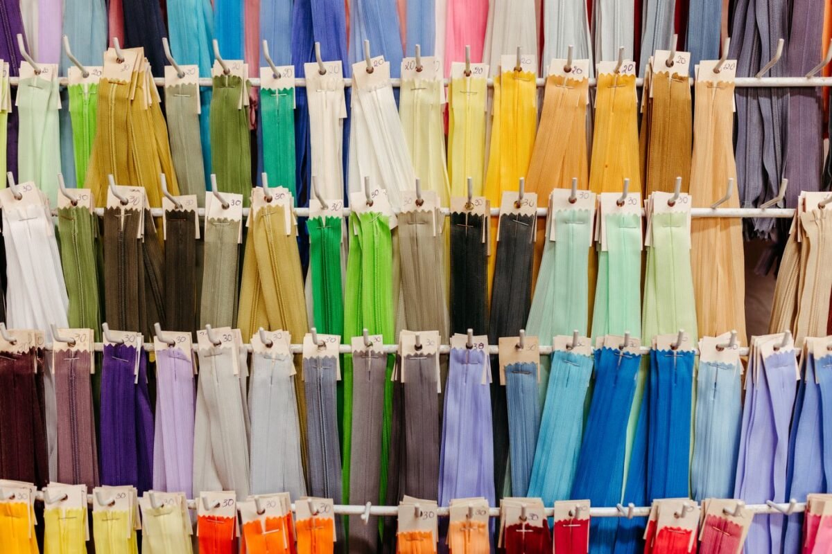 Rows of coloured garment zippers hanging on hooks