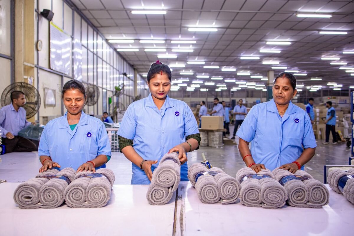 Workers inspecting rolled towels at a home textile factory