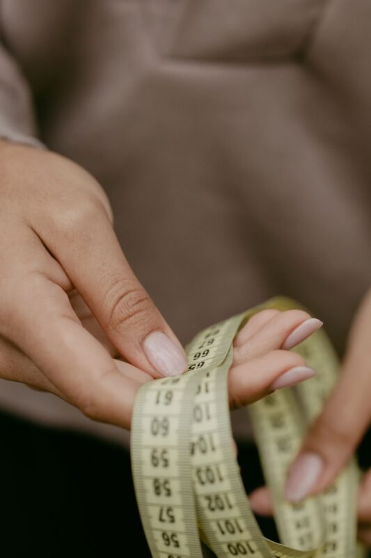 Hands holding a centimetre measuring tape