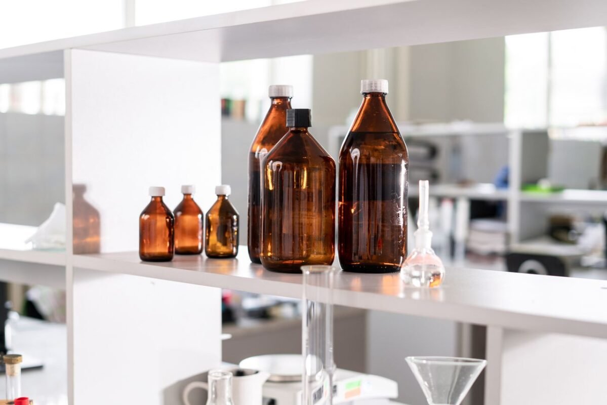 Brown glass chemical reagent bottles on a laboratory shelf