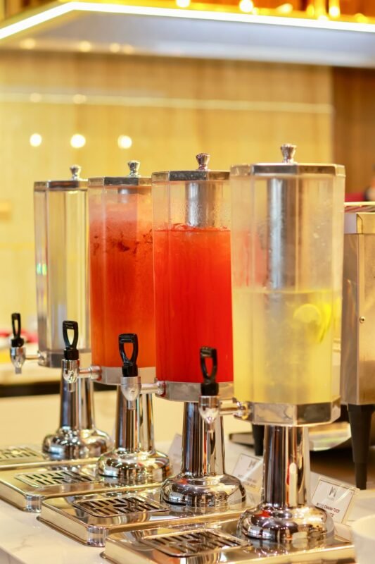 Row of juice dispensers on a buffet counter