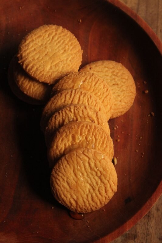 Golden round butter biscuits on a wooden plate