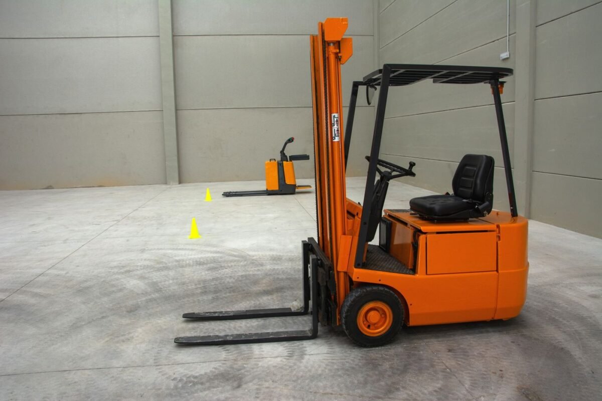 Forklift and pallet truck in a clean warehouse with safety cones