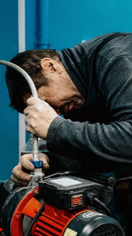 Technician fitting a hose to an electric water pump