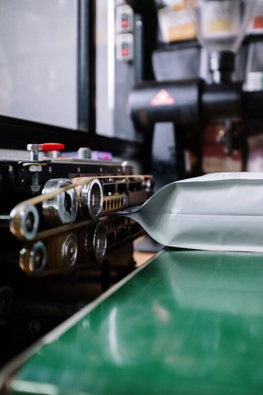 Continuous band sealer closing a filled stand-up pouch