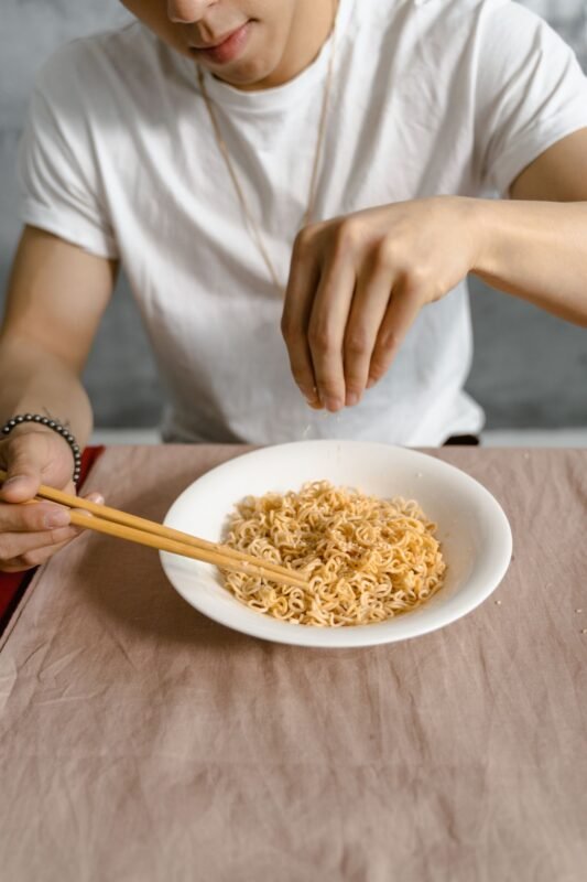Sprinkling seasoning powder over instant noodles