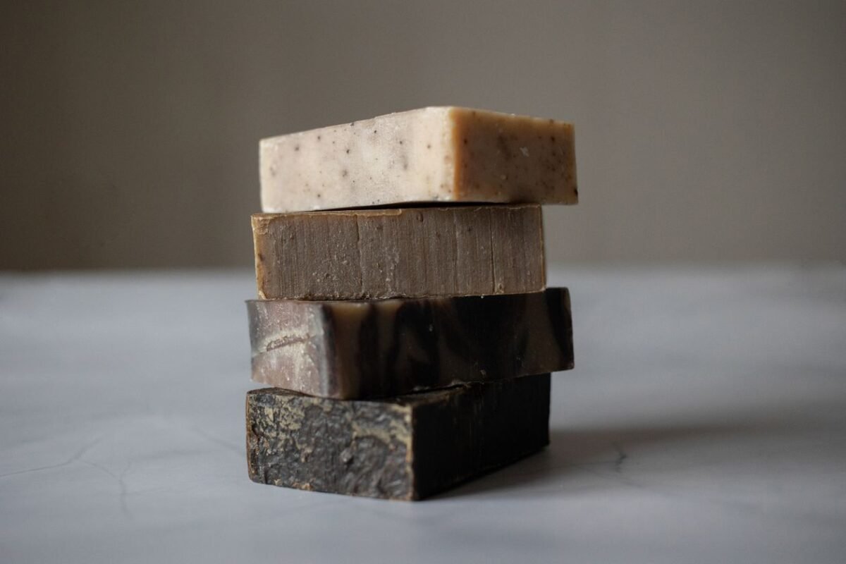 Stack of four bar soaps on a grey table
